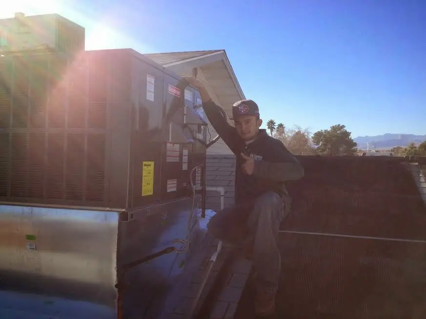 HVAC technician performing Boiler Repair on a rooftop unit in Scottdale